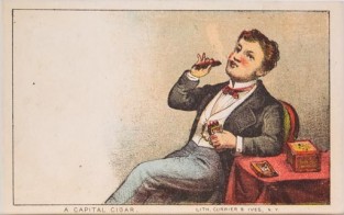 Man seated next to table draped in red cloth