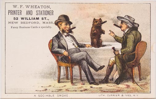 Two men sitting around a table smoking a cigar