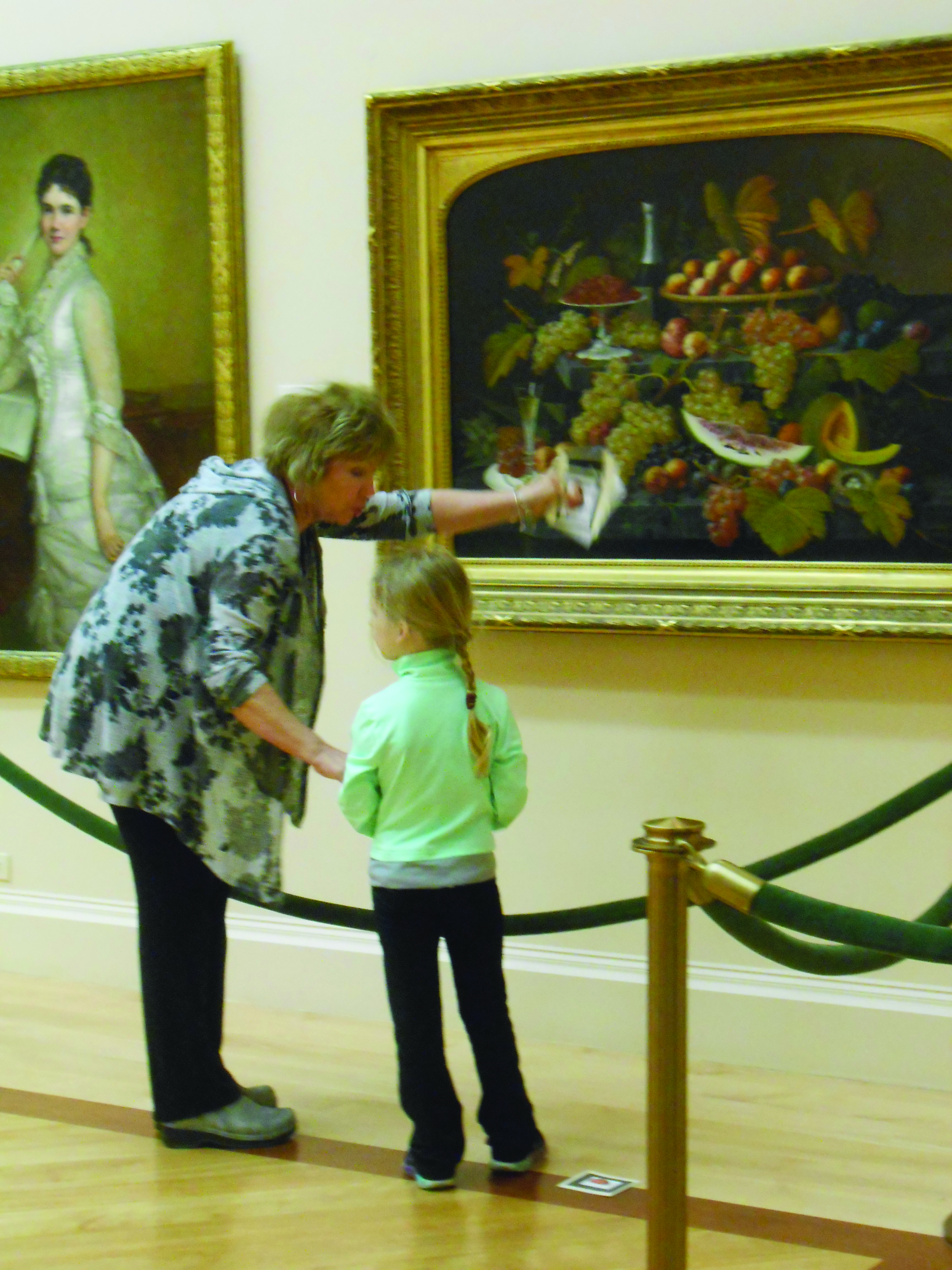 Girl and educator look at painting