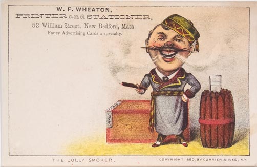 Man in green Turkish hat and blue robe smoking cigar standing in front of a closed box and aside cluster of banded upright cigars