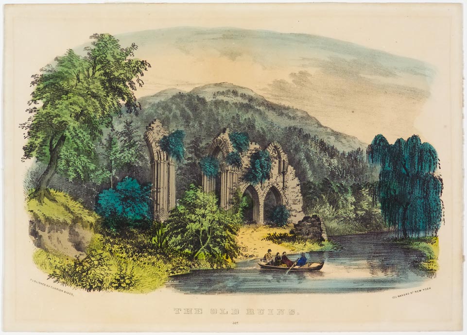 Ruins of castle along riverbank at foothills of mountains