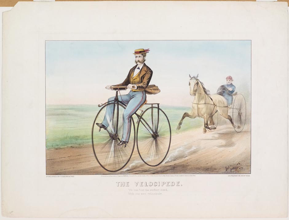 Man riding high two wheel bicycle down lane in front of horse and harness rider