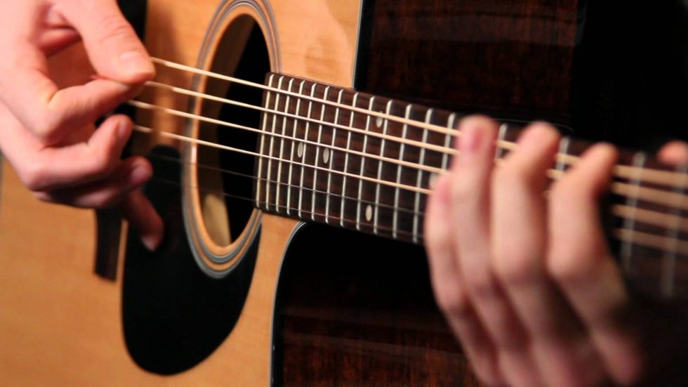 Hands strumming a guitar
