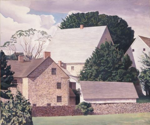 Scene of brick and wood homes crowded with rock wall and trees