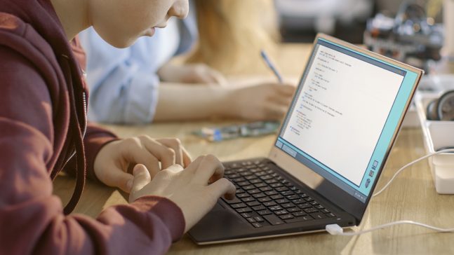 Boy Works on a Laptop at a desk