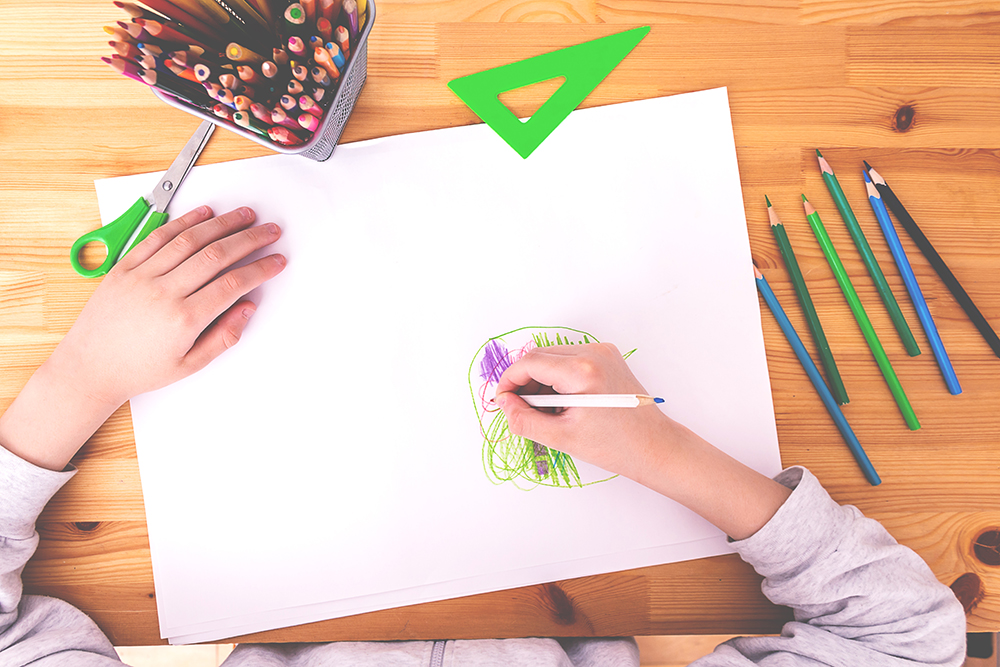 Child draws with crayons
