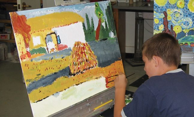 Boy painting a house