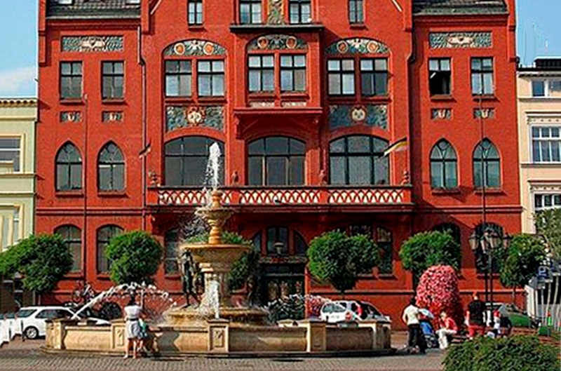Red building with a fountain out front
