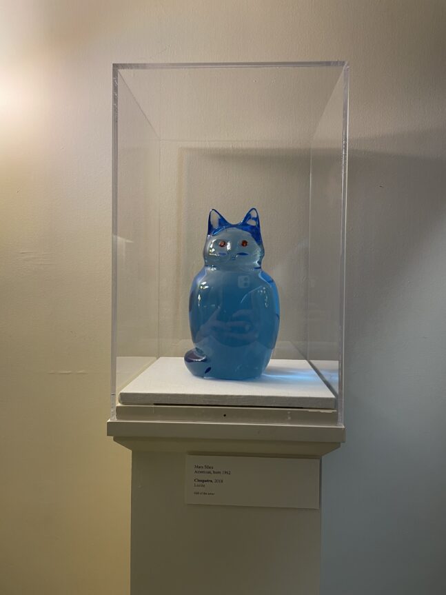 Blue lucite sculpture of cat under a square glass case