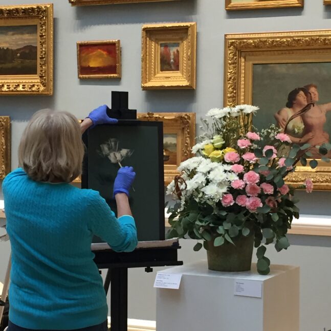 Woman painting a still life of flowers