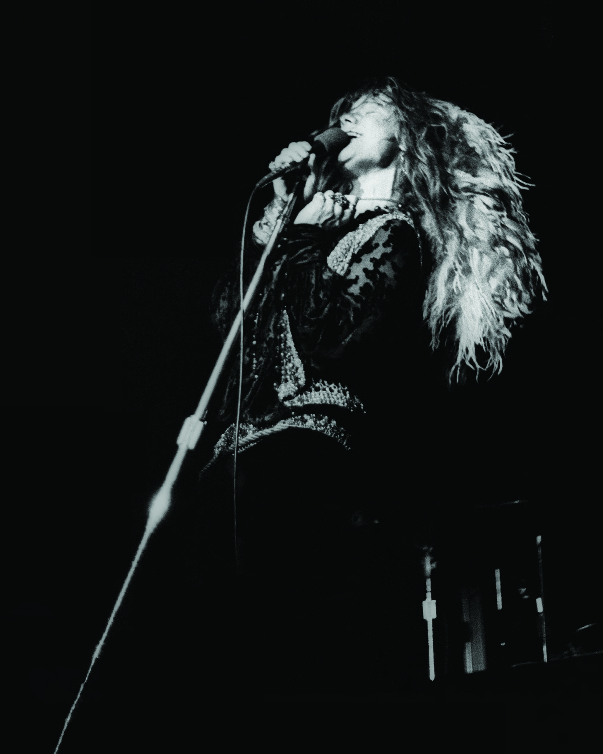 A woman leans back, singing into a microphone