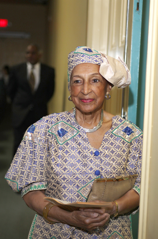 Photo of an African American woman in a printed dress and matching hat