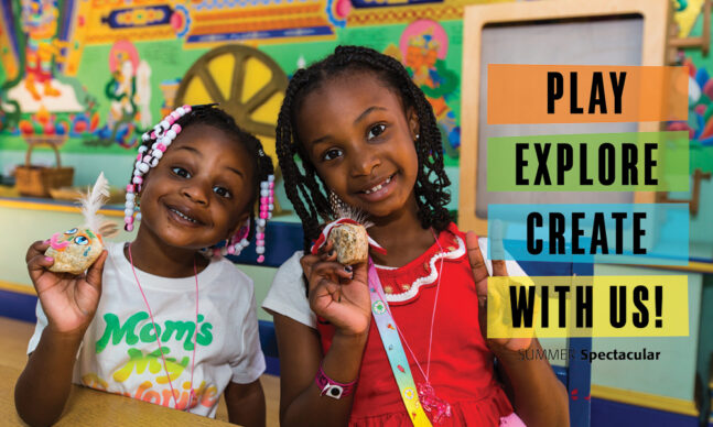 Two girls holding up hand-made art