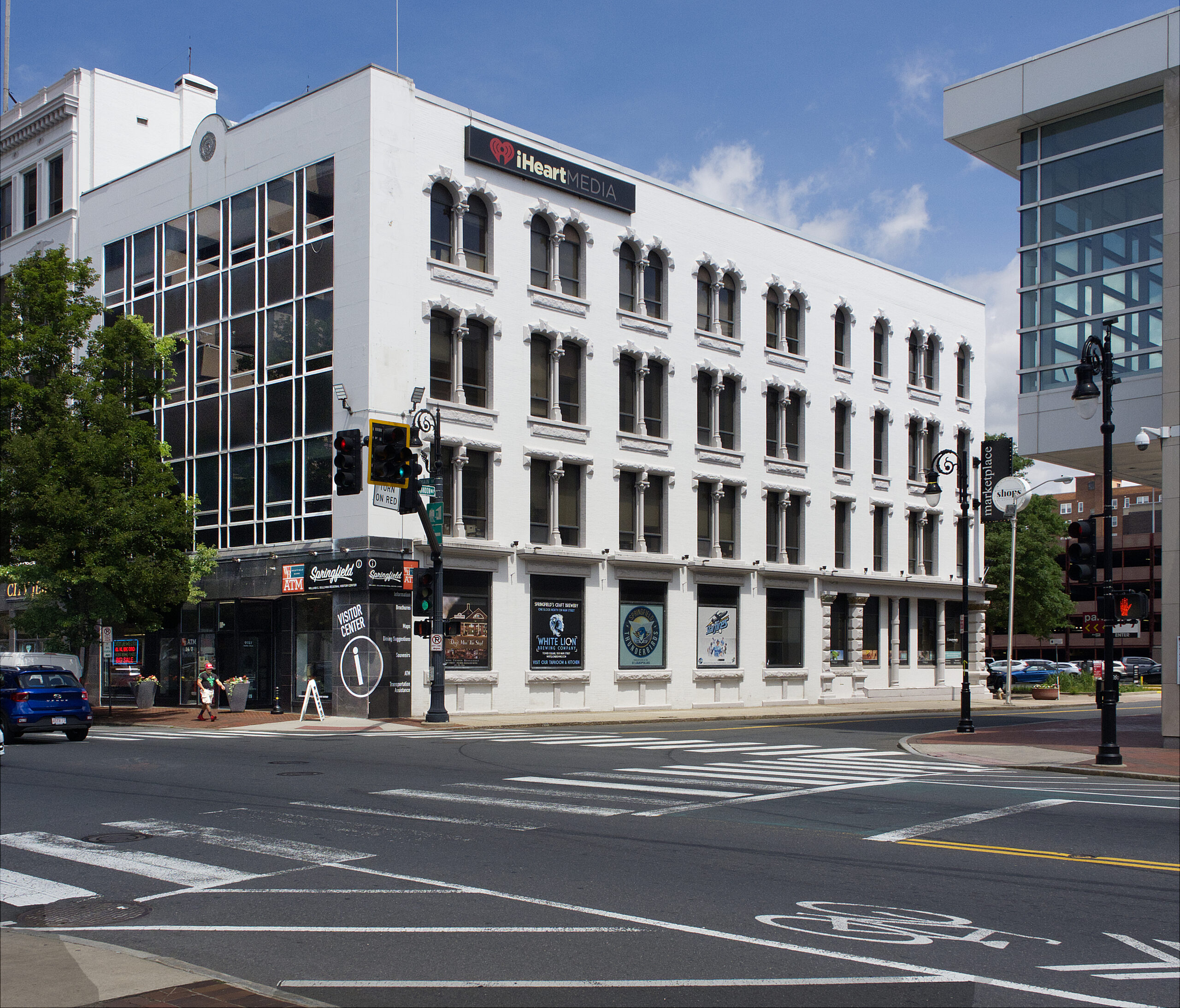 White, four-story building at the corner of an urban intersection