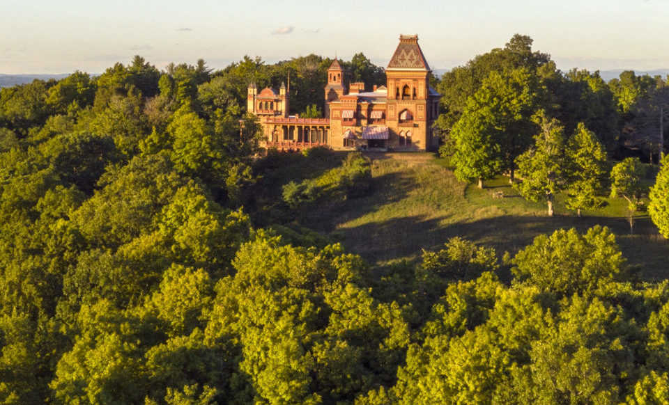 Large home at the top of a hill surrounded by trees