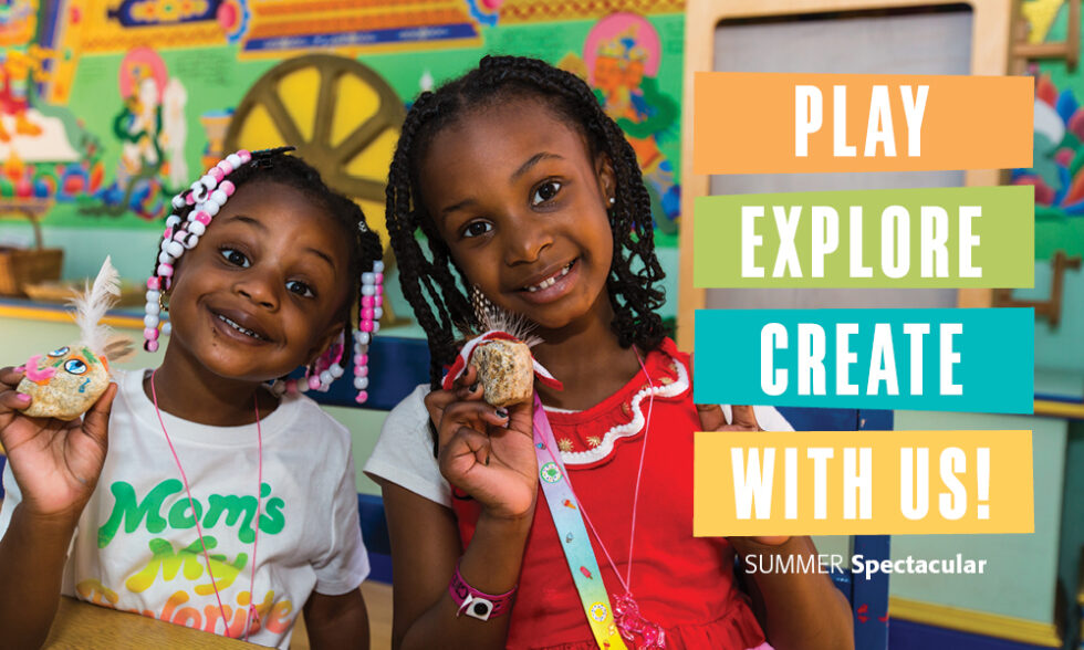 Two girls smile holding craft projects