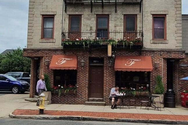 Restaurant with brick exterior and red awnings.