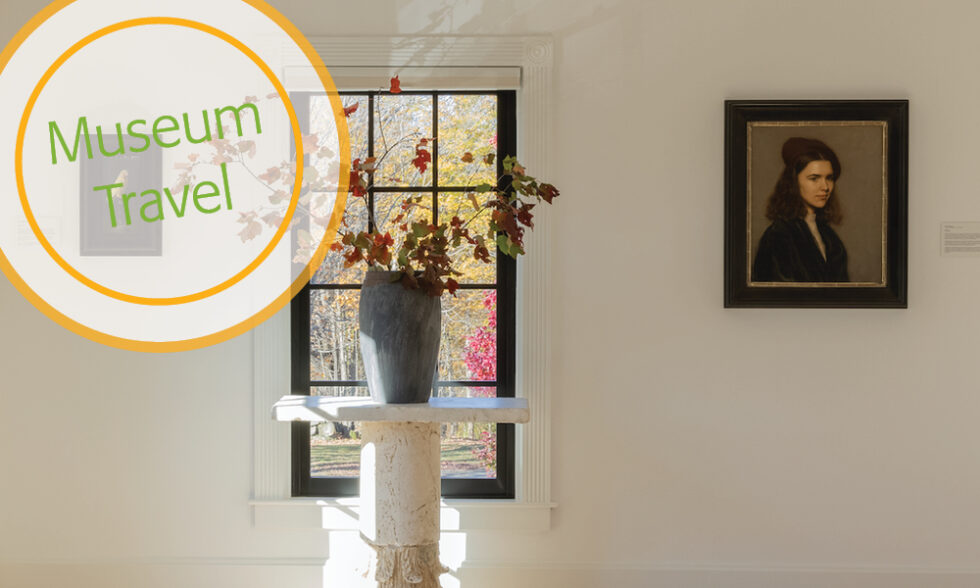 Floral arrangement in front of a window with a portrait of a young woman at right.