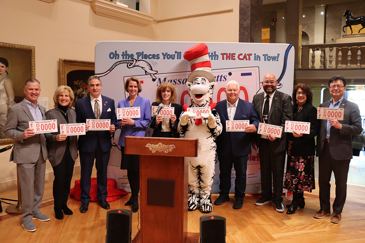 Group of people holding Massachusetts license plates, with a Cat in the Hat costumed character