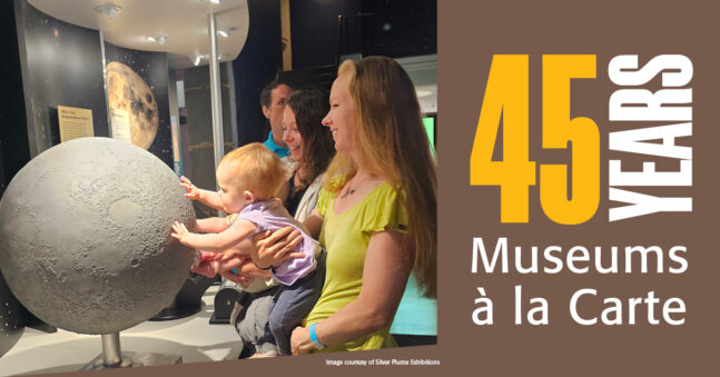 Family examining a tactile moon exhibit