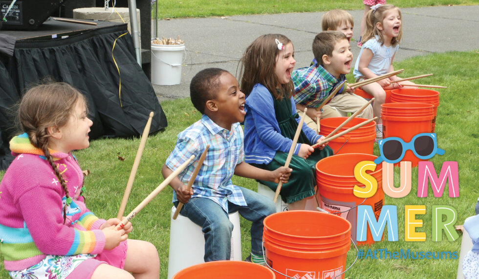 Kids drumming on large orange buckets
