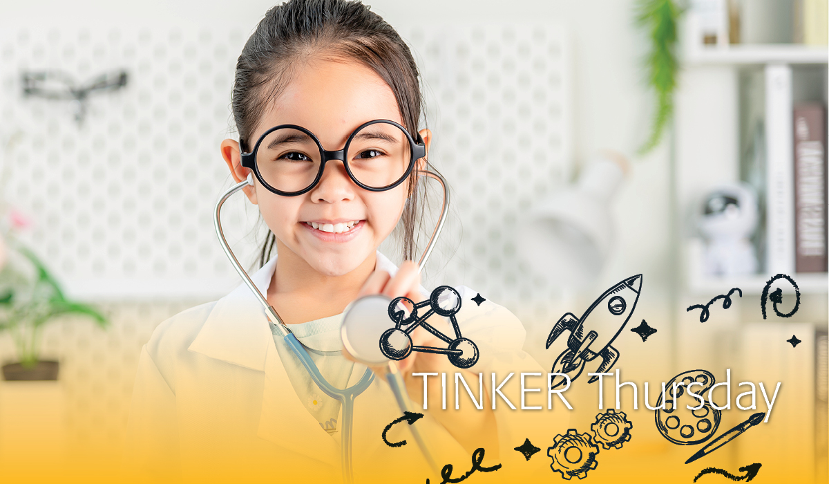 Girl dressed in a lab coat wearing a stethoscope