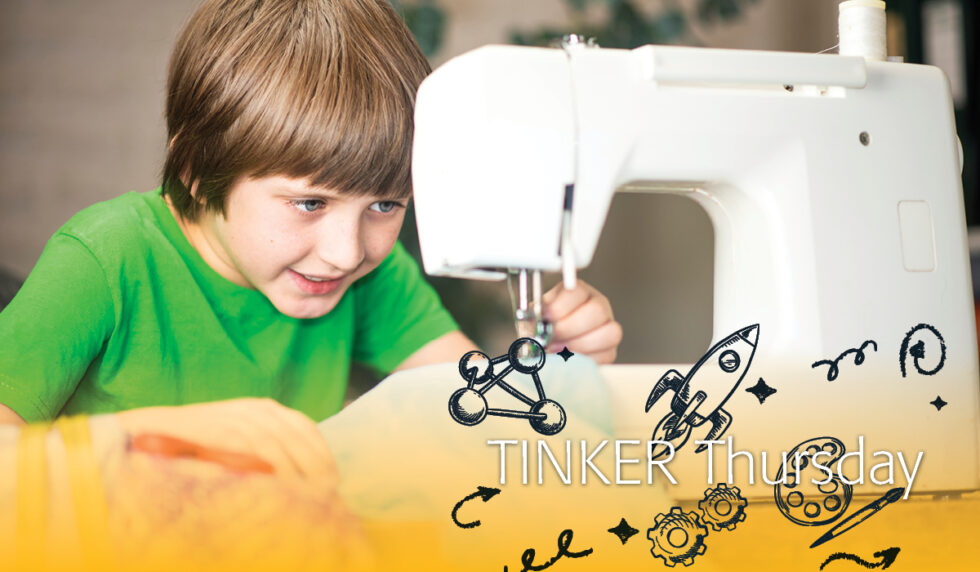 Boy seated at sewing machine