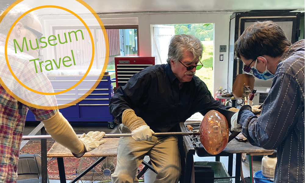 Men working with colorful blown glass in a hot shop