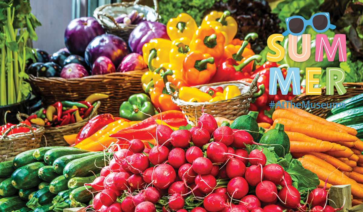 radishes, zucchini, and various peppers displayed at a farmers market