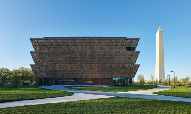 Exterior of the Smithsonian Museum of African American History and Culture with the Washington Monument to the right.