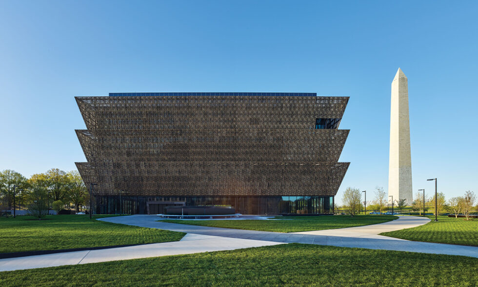 Exterior of the Smithsonian Museum of African American History and Culture with the Washington Monument to the right.